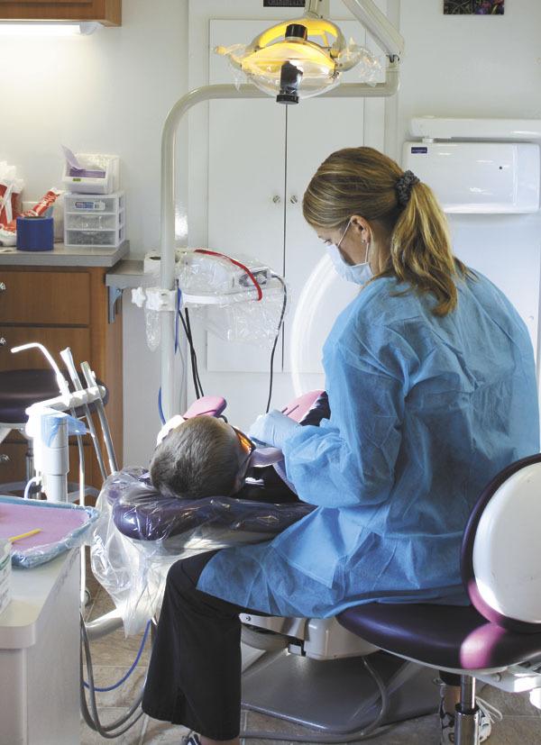 Hygienist Jenny Wegley cleans a first-grader’s teeth last week.