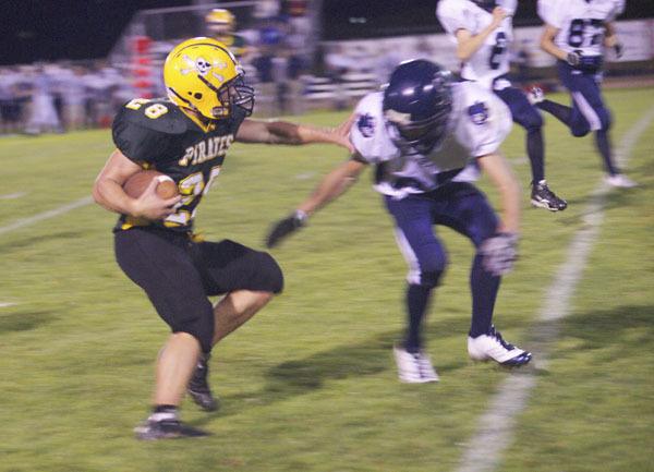 Nick Betz fends off a Cougar tackler near the end of Friday’s football game.