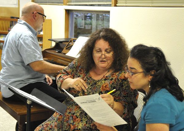 Evan Stults plays the piano while Marita Ericksen and Julea Gardener practice a piece.