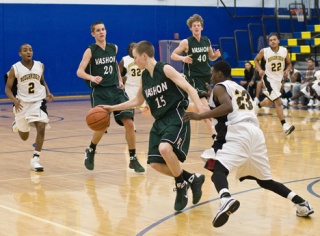 Elias Weston dribbles out of trouble versus the Roosevelt Roughriders in Gresham. Behind him are Alex Wegner