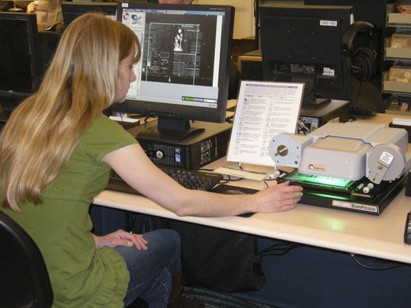 Library staff member Amelia Lincoln demonstrates the new microfilm and fiche reader.