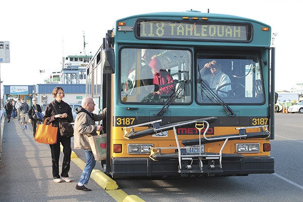 Bus riders at the north-end ferry terminal load a bus on route 118