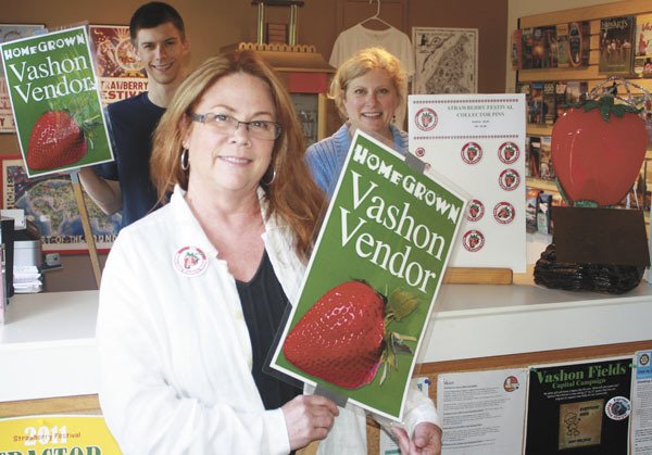 Debi Richards and the Vashon Island Chamber of Commerce staff show off special signs for Island vendors.