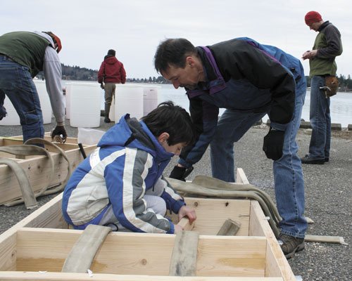 Cub Scout Chick Green and his father Charles help build a raft at Saturday’s work party.