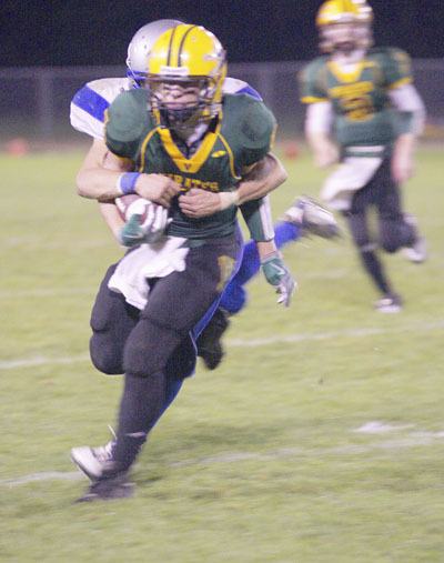 Peter Evans fights for every inch of yardage as a Chimacum tackler hangs on.