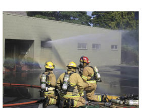 Firefighters finish extinguishing the blaze at IFC International/Jones and Stokes on Bank Road Saturday