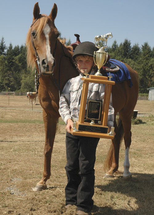 Roehre Cunningham displays a trophy he won at the county fair.