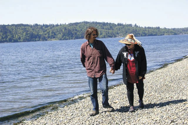 Odin Lonning and Ann Stateler — aka “Orca Annie” — stroll the beach near their home.