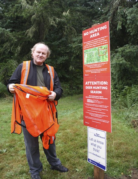 David Kimmett stands next to one of the new signs at Island Center Forest; this one designates a small area closed to hunting.