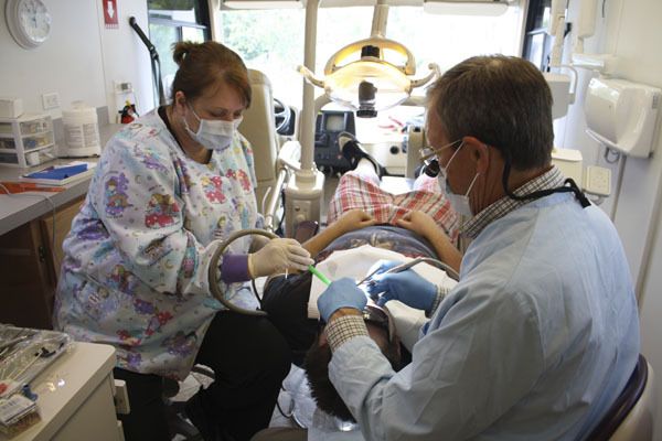 Dr. Cliff Eckman and Denise Folk give a patient fillings last week.