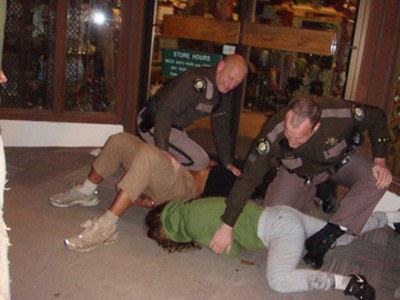 This photo taken Friday night shows the two officers on duty that night. One attempts to arrest Islander Jessica DeWire