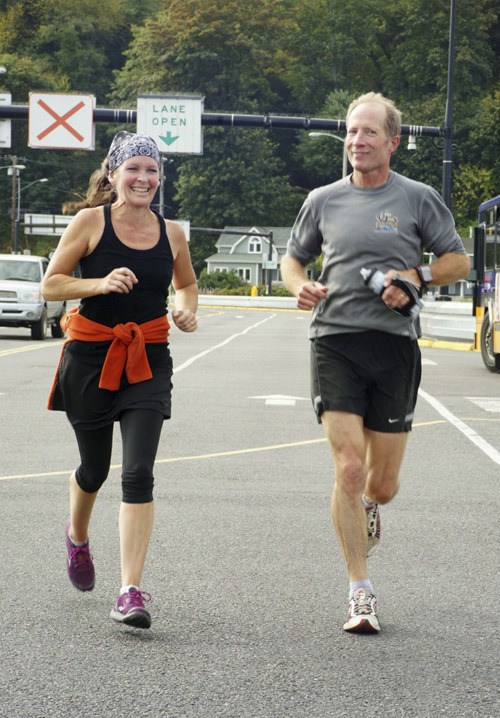 Lisa and Bruce Cyra sprint for the gate at the north-end dock to finish the run together. In addition to having had three children in the VHS cross-country program