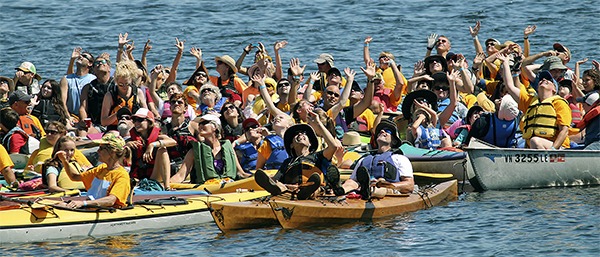 Paddlers wave at a small drone that took photos of Raft Up.