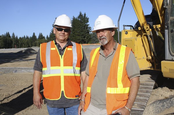 Project manager Tom Ossinger (left) and site superintendent Mike Mattingly say crews are working hard to get grass planted at the fields site before the fall rain begins.