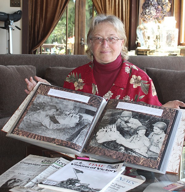 Nancy Bachant shows a scrapbook she has put together chronicling part of her family's history.