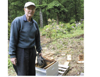 Bob Rice stands next to his demolished bee hives