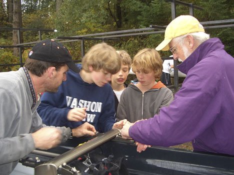 Master rowers Bob Horsely and Jim Hauser help novice rowers Tate Gill