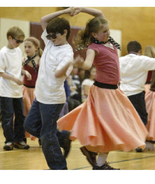 Sam Plauche and Grace Riggs dance together in a rousing version of “Rockin’ Robin” at the Third-Grade Performance on June 6. The three third-grade classes sang and danced to 40 songs during the show