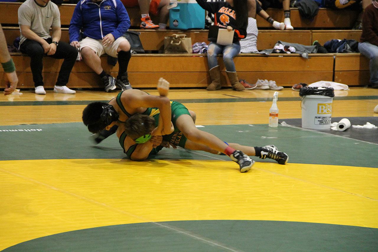 Two Vashon High School wrestlers (top: freshman Moses Kilpatrick and bottom: junior Ben Angelacos) go head-to-head in a semi-final round at The Rock Island wrestling tournament Saturday. VHS has a young team this year with nearly half the team being underclassmen. (Anneli Fogt/Staff Photo)