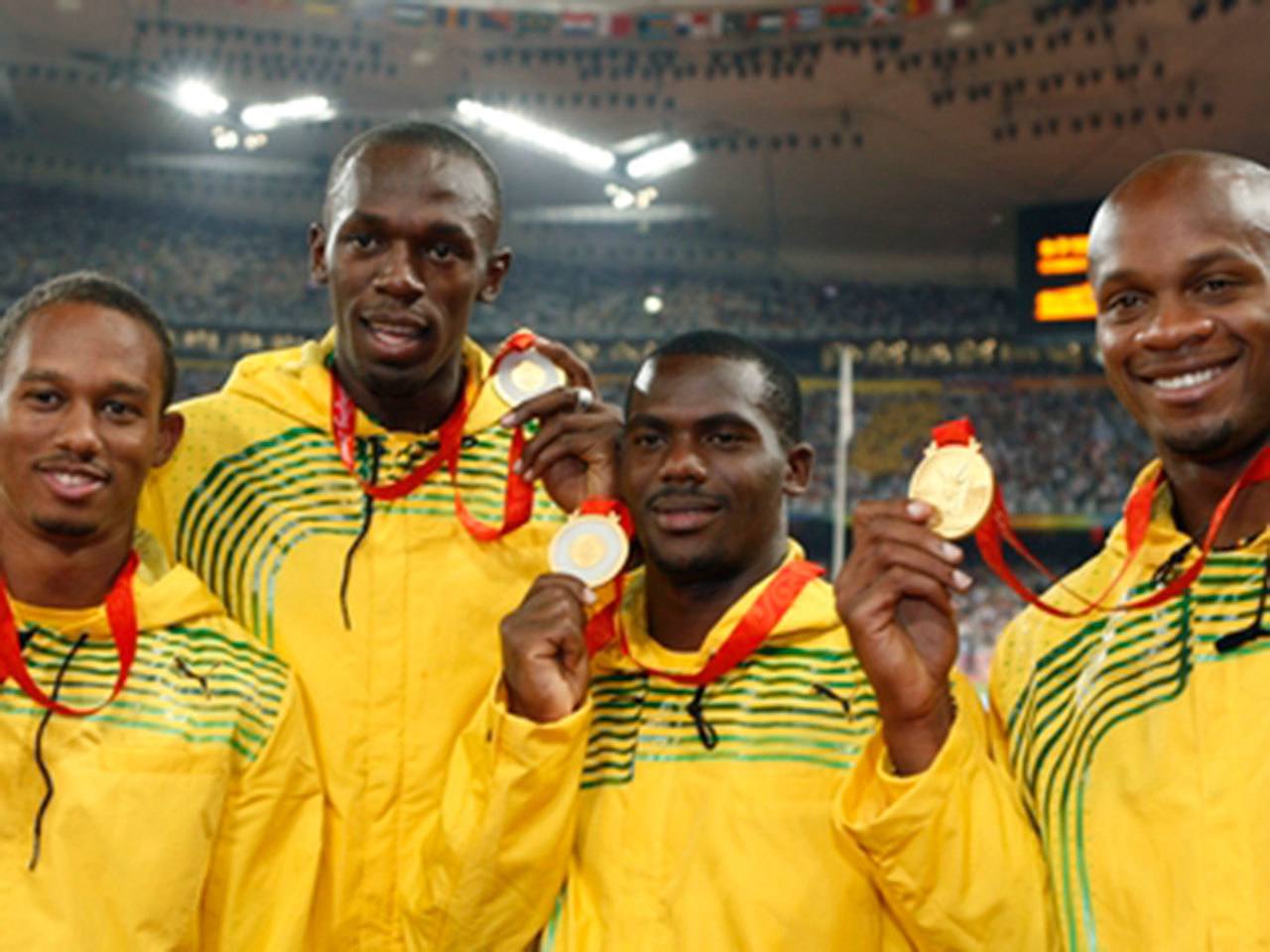 Usain Bolt (center-left) and Nesta Carter (center-right) with their teammates on the podium after winning the men’s 4x100 relay at the 2008 Beijing Olympics. (Reuters Photo)