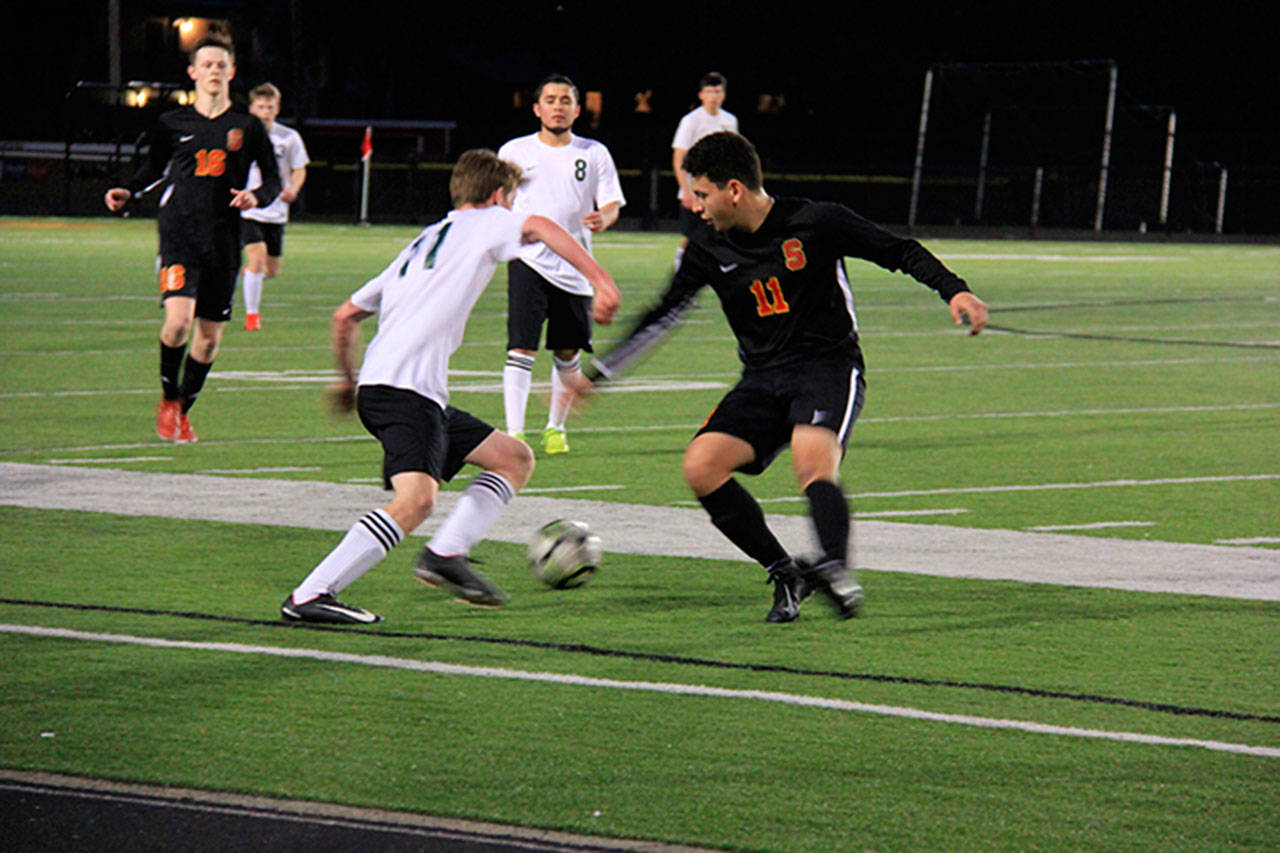 Jakob Heuschert, number 11 in the white shirt, vies for the ball in the match against Steilacoom. Pirate Fredi Gutierrez, number 8, is nearby (Rosie Eades Photo).