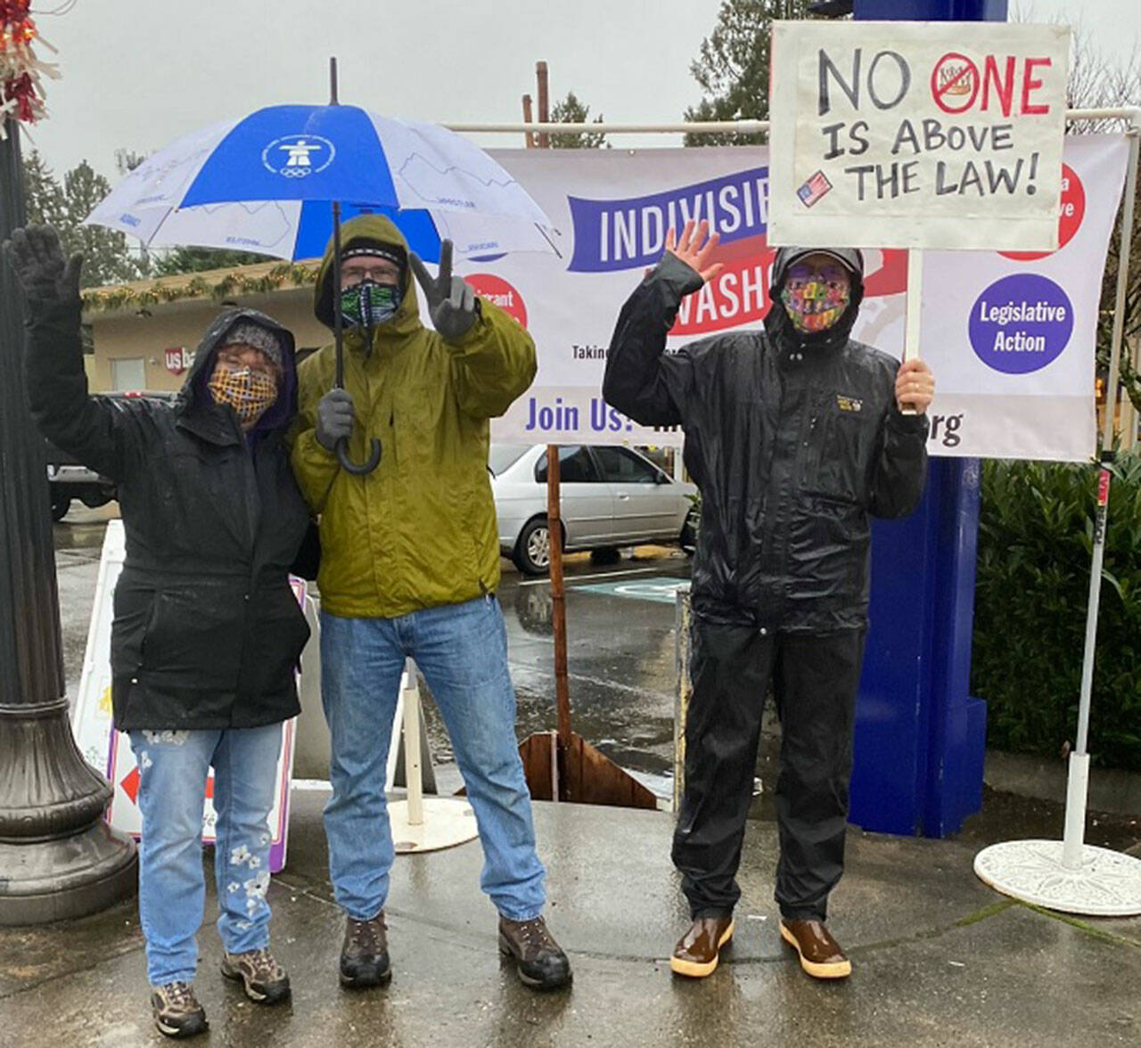 (Jenna Riggs Photo) Rain gear, umbrellas and camaraderie were all on display at Indivisible Vashon’s action marking January 6.