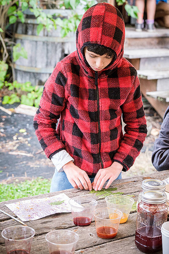 A Chautauqua student creates nature art with fern leaves and hand-made paint created from wild berries harvested from the school’s woodlands (Dawn Stief Photography).