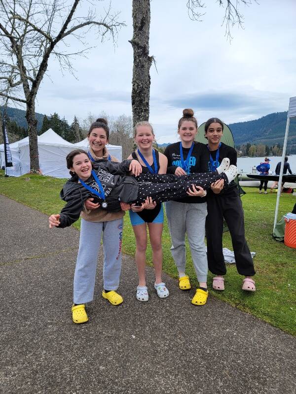 (Left to right) rowers Yvie Hu, Gwyn Ranney, Kina Ladbon-Reusch, and Pearl Henson hold coxswain Beau Sorensen (Courtesy Photo).