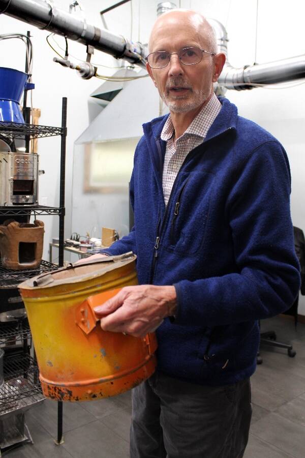 Burn Design Lab Executive Director Paul Means holds a stove that was made by hand; an impressive feat of manual engineering, but one that’s difficult to produce at scale, Means said (Photo by Alex Bruell).