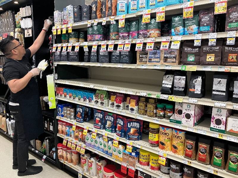 Last week, a store worker cleaned the coffee aisle of Thiftway near the empty spot where Monastery Blend Coffee had been displayed (Elizabeth Shepherd Photo).