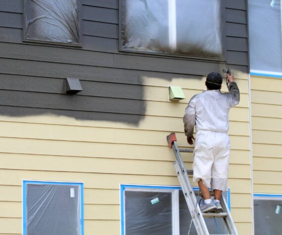 A worker paints a building on July 17 at Vashon HouseHold's upcoming Island Center Homes. (Alex Bruell photo)