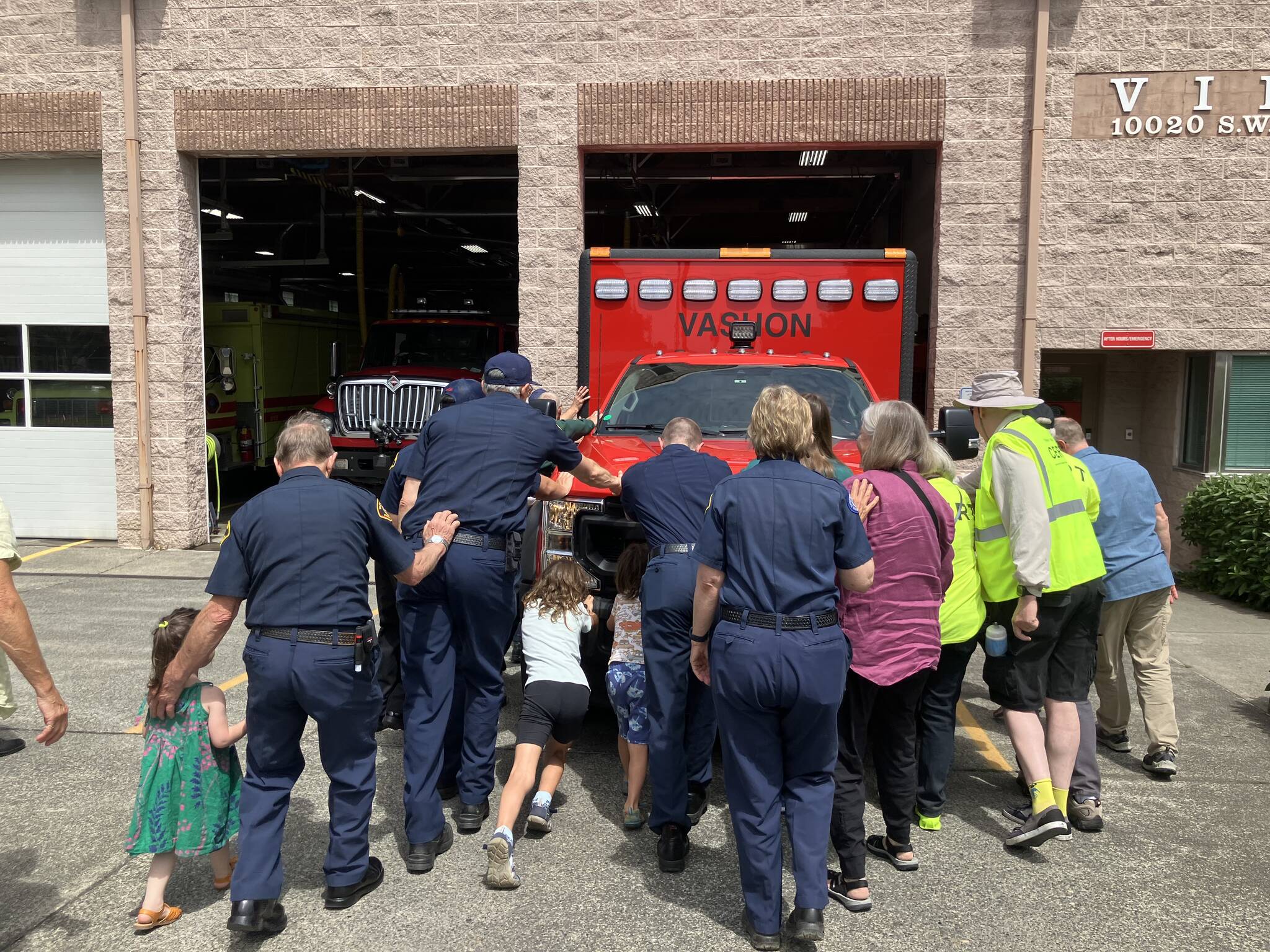 Elizabeth Shepherd Photo
Islanders help first responders push a new ambulance into Station 55, on Bank Road, during a firehouse ceremony that dates back to the 1800s.