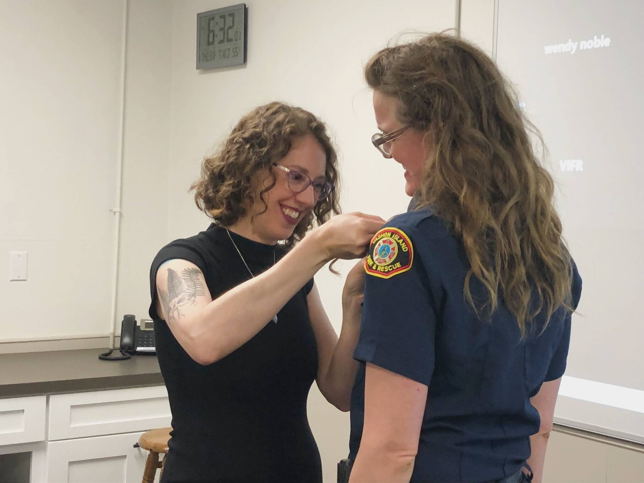 As is tradition in the fire service, Volunteer Firefighter Jenny Gogarten’s badge was pinned by her wife during the VIFR meeting, with their two children eagerly watching. (Alex Bruell photo)