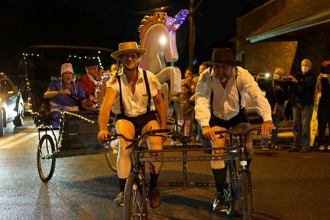 Jason Culp (left) and crew added a sparkling unicorn to their Amish buggy bike in a past Stupid Bike Night on Vashon. (Pete Welch photo.)