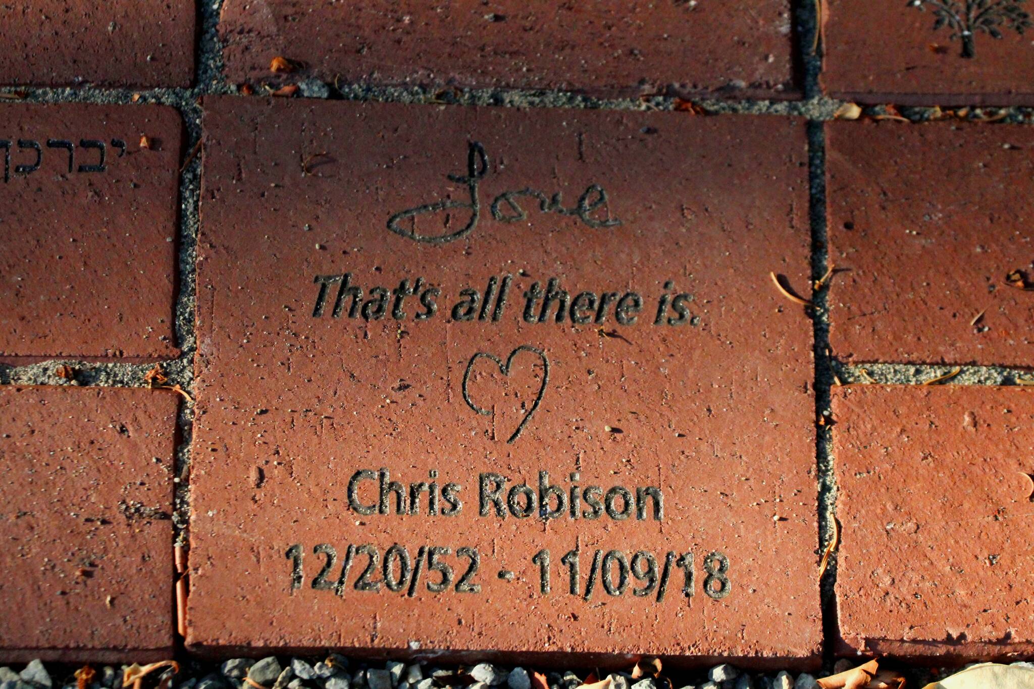 A brick at the Vashon Havurah’s new memory garden reads: “Love / That’s all there is.” in remembrance of Chris Robison. (Alex Bruell photo)