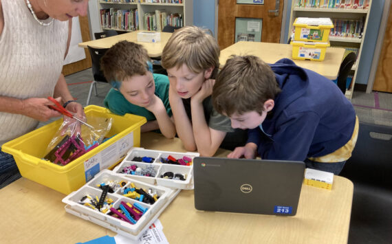 Marie Koltchak photo
(From left to right) Teacher-librarian Kathleen Lawrence, sixth-graders Skyler McMillen-Meyers and Brooks Johnson, and fifth-grader Simon Tilden open a new box of Lego materials.