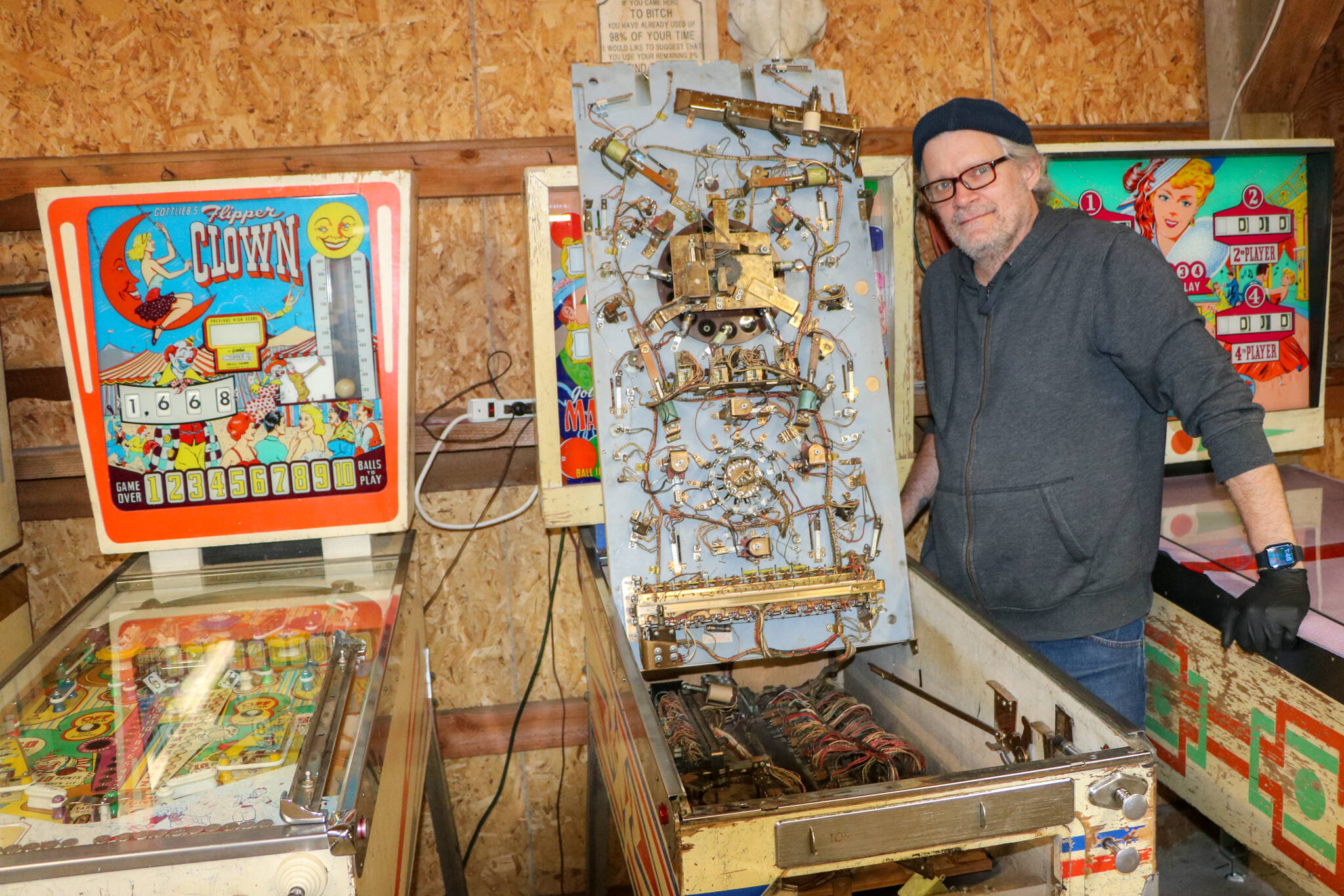 Mo Davis stands next to the inner workings of one of his pinball machines. (Aspen Anderson photo)