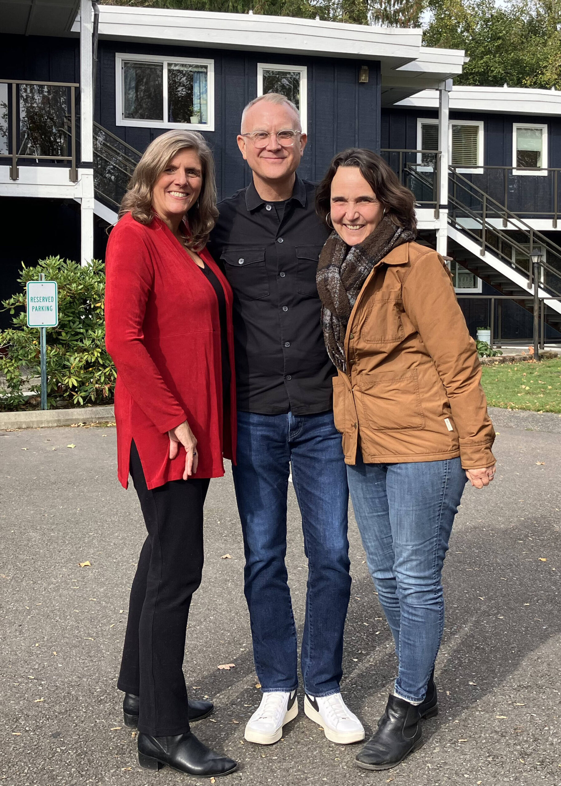 (Left to right) Kari Dohn Decker, Jason Johnson and Anne Atwell, standing outside Charter House, a 50-year-old apartment complex that has been rehabilitated by Vashon HouseHold during Johnson’s tenure as the organization’s executive director. (Elizabeth Shepherd photo)