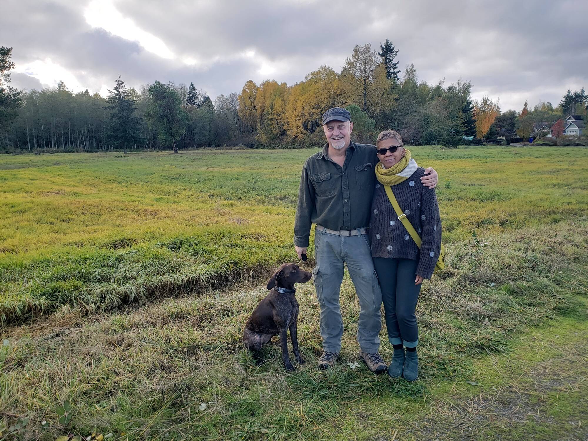 Morgan Brown, Pia Bloom and their dog Suki stand in front of the field on the south side of S.W. 178th. (Leslie Brown photo)