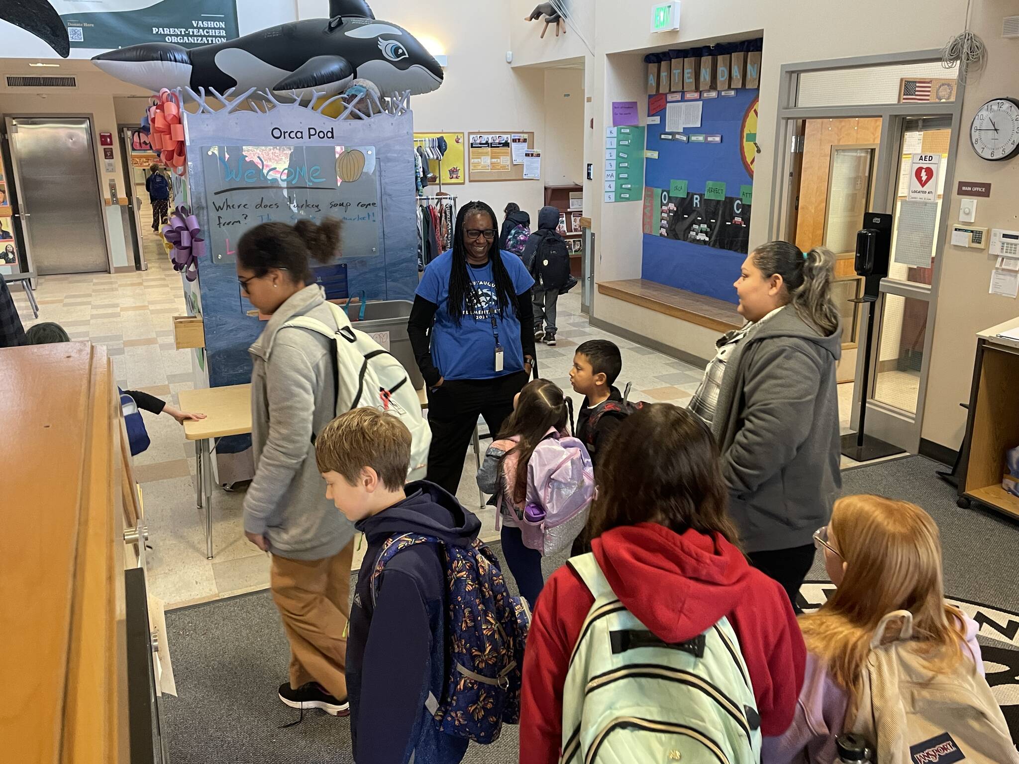 Assistant Principal Karen James, in blue t-shirt and wearing her school lanyard (center) greets students arriving at Chautauqua Elementary School. (Courtesy photo)