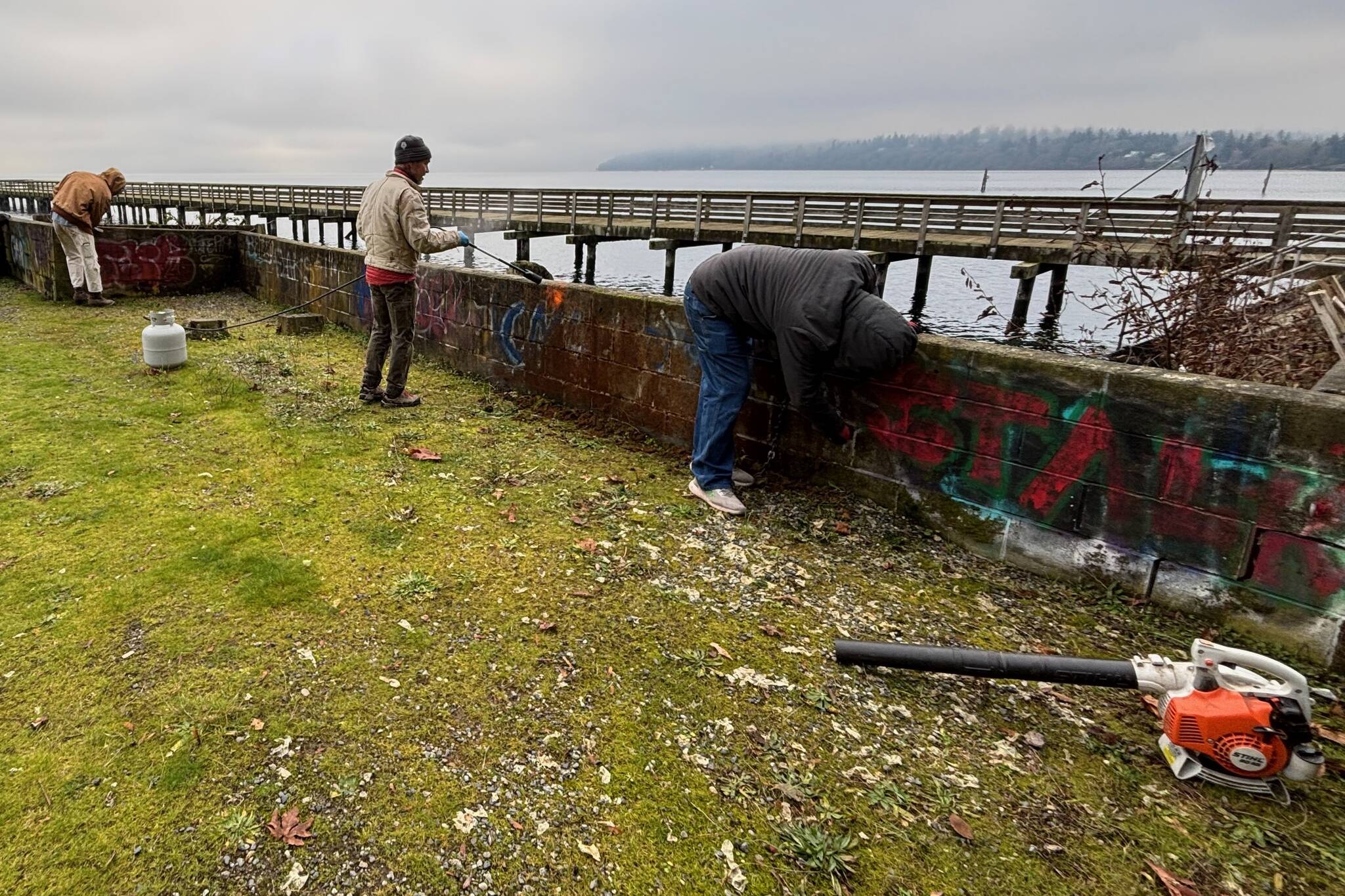 Photo courtesy Bryan Ripka
Volunteers from island-based Meade Building Company painted over graffiti at Tramp Harbor and collecting litter along the Point Robinson and Lisabuela shorelines on Dec. 4 as part of a company volunteer day. In this photo, volunteers clean up at Tramp Harbor Dock. Both the Tramp Harbor Dock and Point Robinson and Lisabeula properties are owned and managed by the Vashon Park District (VPD), whose executive director, Elaine Ott Rocheford, confirmed that Meade had reached out to VPD this fall to volunteer their efforts.